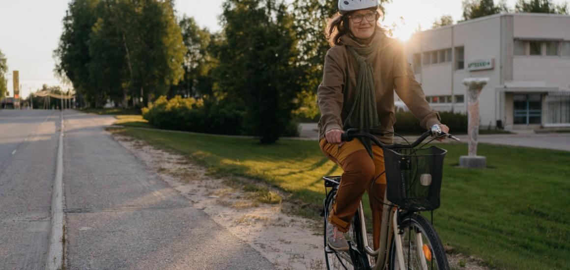Pyöräilijä ilta-auringossa Posion taajamassa.