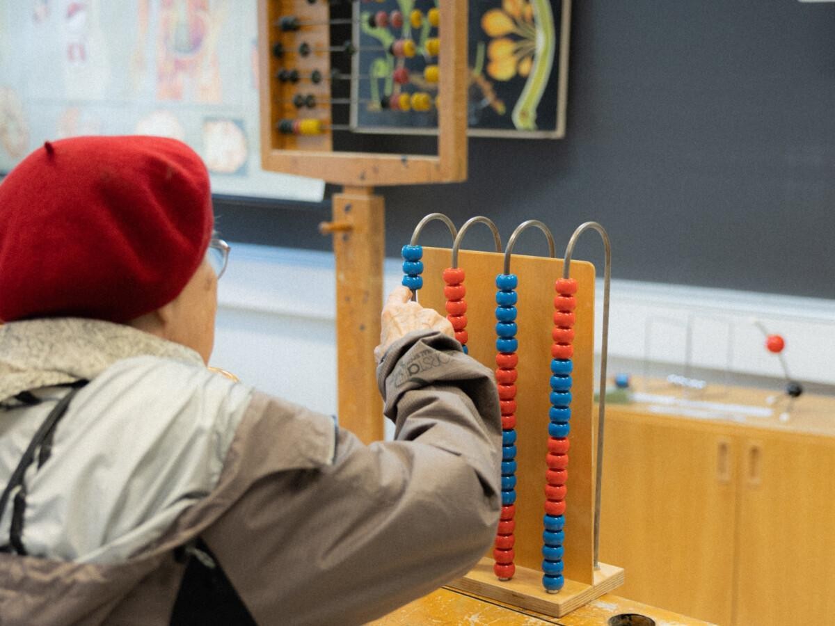 henkilö istuu vanhan pulpetin ääressä