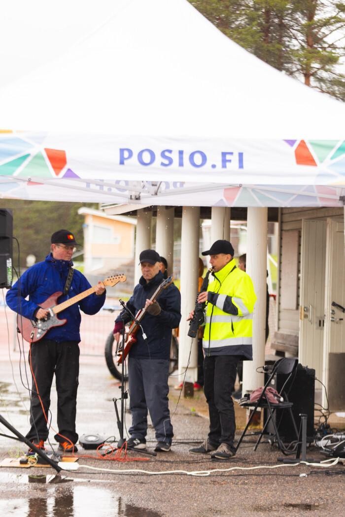 orkesteri soittaa soittimia, ulkoteltta, vesisade